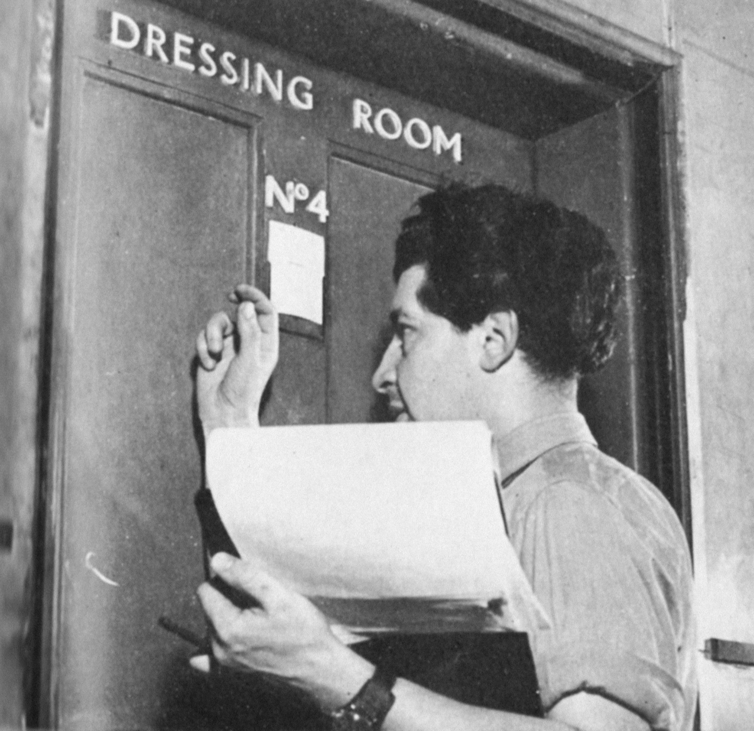 A man knocking on a dressing room door