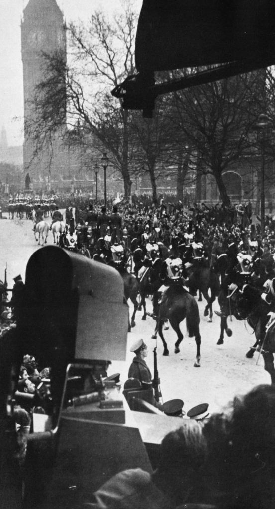 A camera points at soldiers on horse back