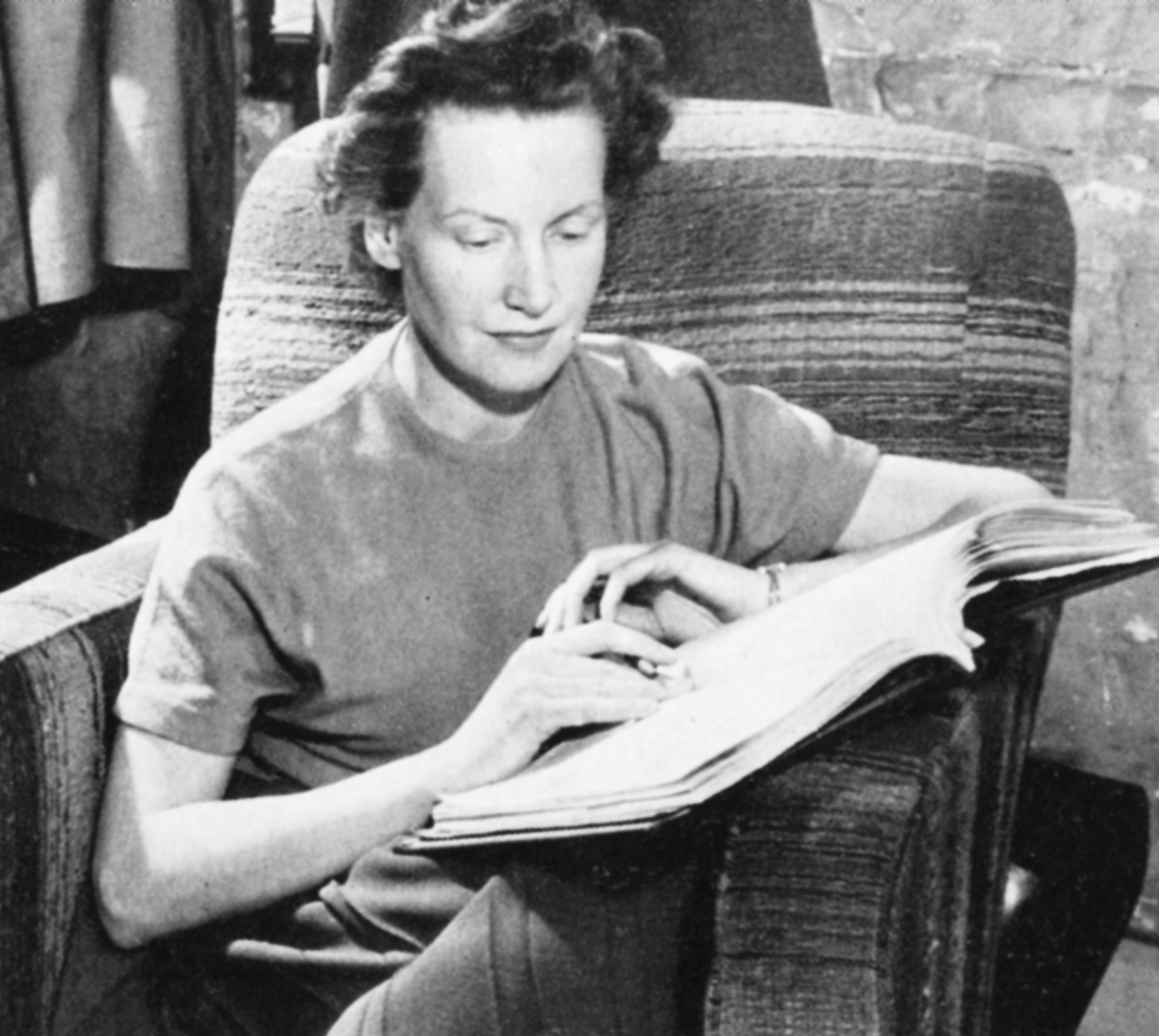 A woman sits with a script book